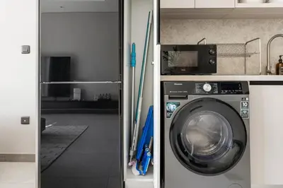 a laundry room with a washing machine in a room at 2.5BR Villa | PS5 & Private Pool | Near Dubai Mall in Dubai