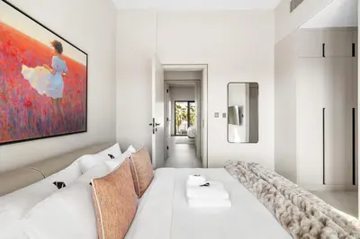 a white living room with a large painting on the wall at 2.5BR Villa | PS5 & Private Pool | Near Dubai Mall in Dubai
