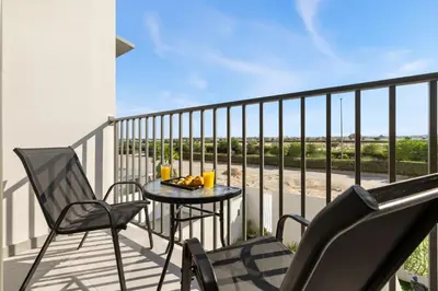 a balcony with a table and chairs on a balcony at 2.5BR Villa | PS5 & Private Pool | Near Dubai Mall in Dubai
