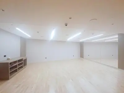an empty room with white walls and a wooden floor at Vacationer l Contemporary 1 Bedroom l Free Pool, Gym Access in Dubai