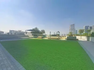 a park with green grass and buildings in the background at Vacationer l Contemporary 1 Bedroom l Free Pool, Gym Access in Dubai