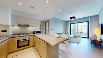 a kitchen and living room with a large window at Vacationer l Contemporary 1 Bedroom l Free Pool, Gym Access in Dubai