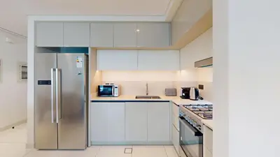 a kitchen with white cabinets and a stainless steel refrigerator at Vacationer l Stunning 2 Bed l Marina Skyline l Beach Access in Dubai
