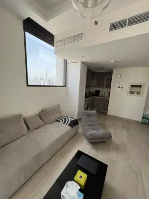 a living room with a couch and a table at Luxurious One Bedroom Apartment - Azizi Riviera in Dubai