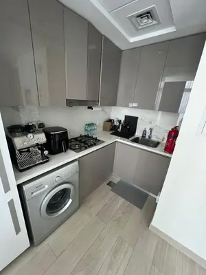 a kitchen with a washing machine and a sink at Luxurious One Bedroom Apartment - Azizi Riviera in Dubai