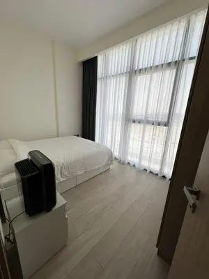 a bedroom with a bed and a large window at Luxurious One Bedroom Apartment - Azizi Riviera in Dubai