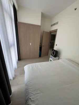 a bedroom with a white bed and a television at Luxurious One Bedroom Apartment - Azizi Riviera in Dubai