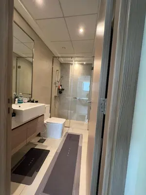 a bathroom with a sink and a toilet and a shower at Luxurious One Bedroom Apartment - Azizi Riviera in Dubai