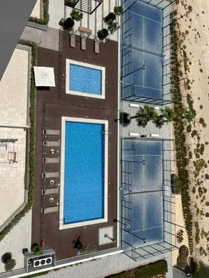 an overhead view of a building with two swimming pools at Luxurious One Bedroom Apartment - Azizi Riviera in Dubai