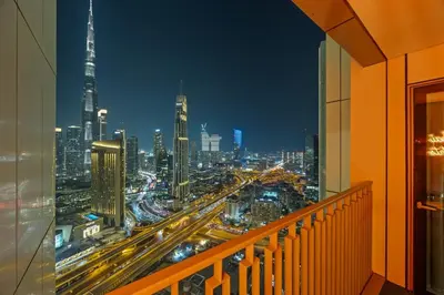 a view of a city at night from a balcony at Hermès 2BR Burj Khalifa & Fountain View With Direct Dubai Mall Access in Dubai