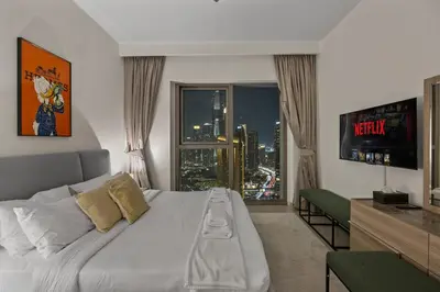 a bedroom with a bed with a view of a city at Hermès 2BR Burj Khalifa & Fountain View With Direct Dubai Mall Access in Dubai