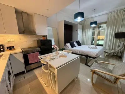 a kitchen and living room with a bed in the background at Cozy Studio in the Heart of Dubai Marina in Dubai