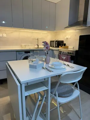 a kitchen with a table with glasses and flowers on it at Cozy Studio in the Heart of Dubai Marina in Dubai