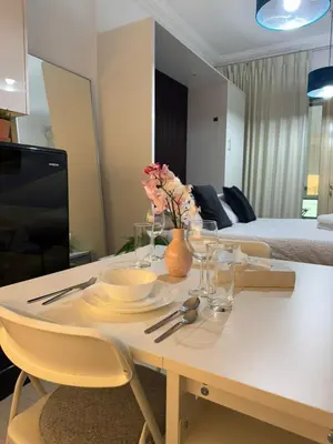 a living room with a table with plates and glasses at Cozy Studio in the Heart of Dubai Marina in Dubai