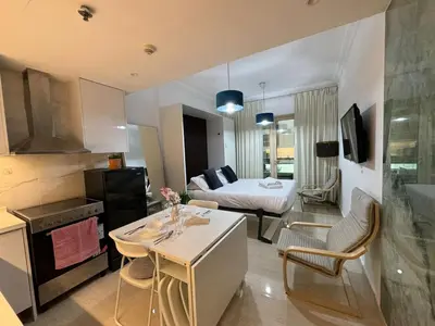 a kitchen and a living room with a bed and a table at Cozy Studio in the Heart of Dubai Marina in Dubai