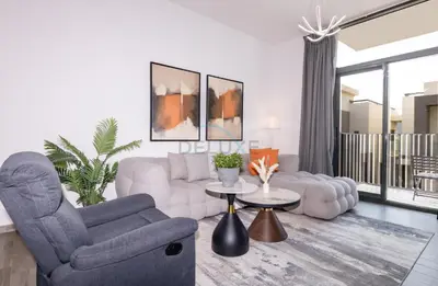 a living room with a couch and a chair at Central Location with Easy Access to Al Khail Road, Near Bus Stops, Supermarkets, Dining Spots, Minutes from Dubai Marina and Downtown - Belgravia Square B, JVC by Deluxe Holiday Homes in Dubai