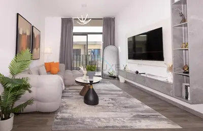 a living room with a white couch and a tv at Central Location with Easy Access to Al Khail Road, Near Bus Stops, Supermarkets, Dining Spots, Minutes from Dubai Marina and Downtown - Belgravia Square B, JVC by Deluxe Holiday Homes in Dubai