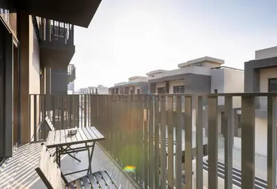 a balcony with a bench and some buildings at Central Location with Easy Access to Al Khail Road, Near Bus Stops, Supermarkets, Dining Spots, Minutes from Dubai Marina and Downtown - Belgravia Square B, JVC by Deluxe Holiday Homes in Dubai