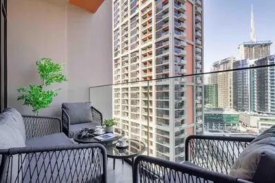 a balcony with a table and chairs and a large window at Frank Porter - Peninsula One in Dubai