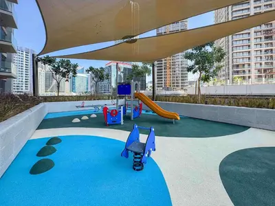 a playground with a slide and a stroller at Frank Porter - Peninsula One in Dubai