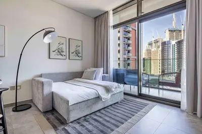 a bedroom with a bed and a large window at Frank Porter - Peninsula One in Dubai