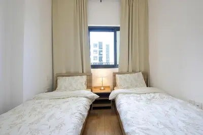 two beds in a small room with a window at Silk Valley - Luxury 2B steps from Metro station in Dubai