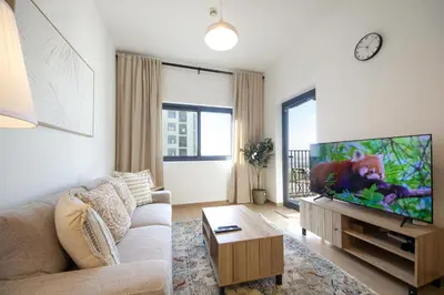 a living room with a couch and a flat screen tv at Silk Valley - Luxury 2B steps from Metro station in Dubai