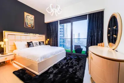 a bedroom with a bed and a sink and a window at NYC x DXB with Full Burj Khalifa View in Downtown Dubai in Dubai