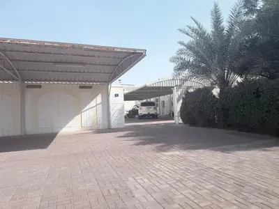 a garage with a palm tree and a truck at Diligence Barsha Apartment in Dubai