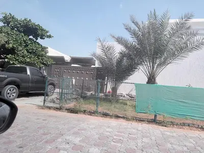 a truck parked next to a fence with palm trees at Diligence Barsha Apartment in Dubai