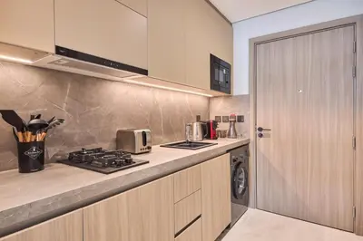 a kitchen with a stove top oven next to a door at Pool View Studio Near to circle mall - Icon casa Living in Dubai