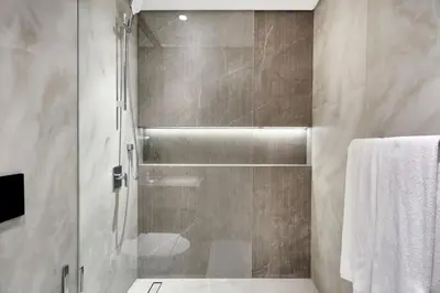 a shower with a glass door in a bathroom at Pool View Studio Near to circle mall - Icon casa Living in Dubai