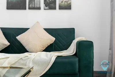 a green couch with a blanket on it in a living room at Stunning 1BR l JLTl Steps to Metro! in Dubai