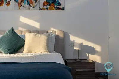 a bedroom with a bed and a table with a lamp at Stunning 1BR l JLTl Steps to Metro! in Dubai