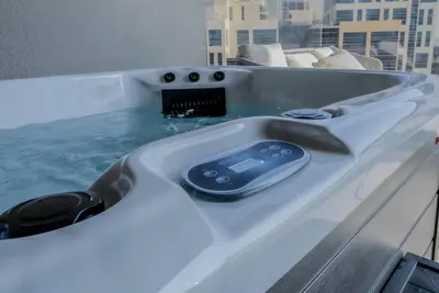 a remote control sitting in a bath tub with water at Designer 2BR with Jacuzzi near Burj Khalifa in Dubai