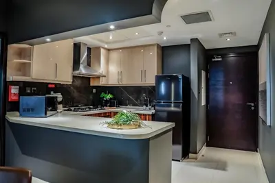 a kitchen with a black refrigerator and a counter at Designer 2BR with Jacuzzi near Burj Khalifa in Dubai