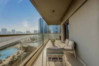 a balcony with two chairs and a view of the city at Designer 2BR with Jacuzzi near Burj Khalifa in Dubai