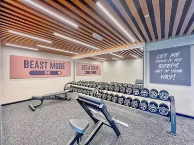 a gym with a row of exercise equipment and signs at Designer 2BR with Jacuzzi near Burj Khalifa in Dubai