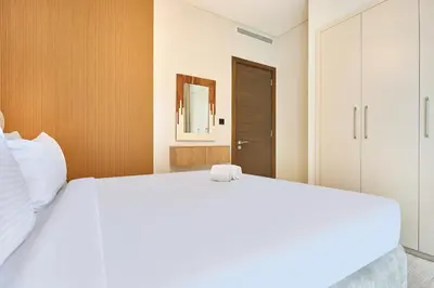 a bedroom with a large white bed and a mirror at STAY BY LATINEM Luxury 1BR Holiday Home CV B 1506 near Downtown in Dubai
