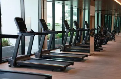 a row of treadmills in a gym at Tranquil 1BR in Binghatti Amber with Free Pool & Gym! in Dubai