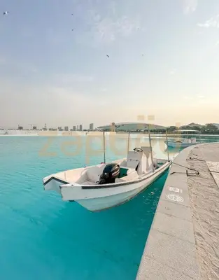 a boat parked next to a dock in the water at Zapbed House-luxury one bedroom apartment in Residence 16 in Dubai