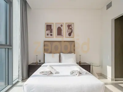 a bedroom with a white bed with towels on it at Zapbed House-luxury one bedroom apartment in Residence 16 in Dubai
