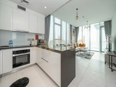 a kitchen with white cabinets and a stove top oven at Zapbed House-luxury one bedroom apartment in Residence 16 in Dubai