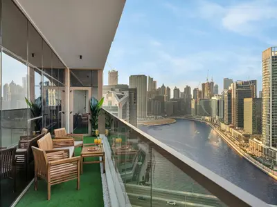 a balcony with chairs and a view of a river at Luxurious 3BR Stunning Canal & Burj Khalifa View in Dubai