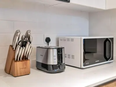 a kitchen counter with a microwave and a knife block at Luxurious 3BR Stunning Canal & Burj Khalifa View in Dubai