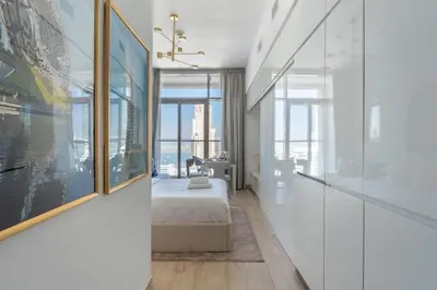 a bedroom with a bed and a large window at GuestReady | Studio | Cozy Apt with Marina View in Dubai