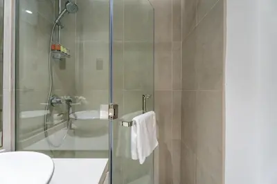a bathroom with a shower with a toilet and a sink at GuestReady | Studio | Cozy Apt with Marina View in Dubai