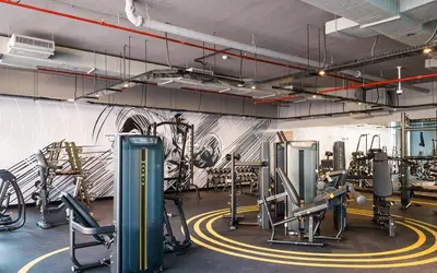 a gym with cardio equipment and a wall with graffiti at GuestReady | Studio | Cozy Apt with Marina View in Dubai