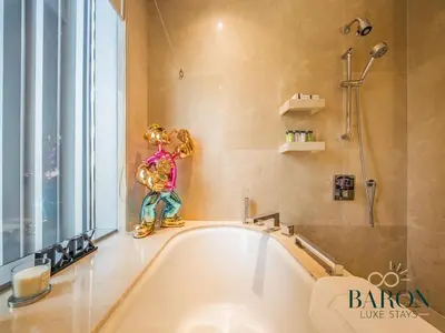a bath tub with a statue of a woman in a bathroom at The Gallery in Dubai