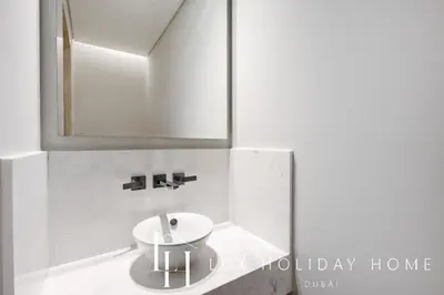 a bathroom with a white sink and a mirror at LUX Iconic Views at The Palm Tower Suite 6 in Dubai